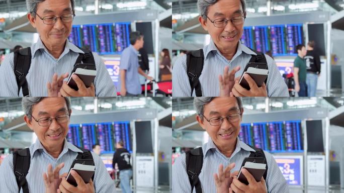 亚洲高级男子正在看他的手机屏幕。他正站在机场，反对电子时间表。旅行，旅程，全球，生活方式，假期，技术