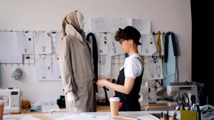 在现代工作室工作的女性设计师将服装放在人体模型上