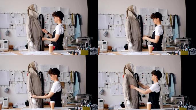 在现代工作室工作的女性设计师将服装放在人体模型上