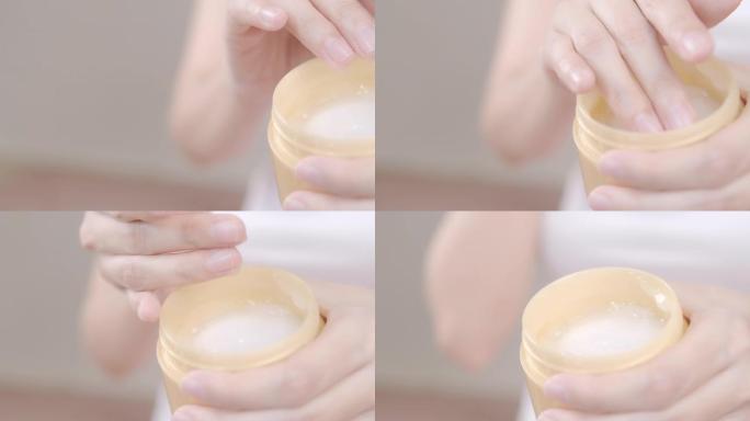 4k分辨率的亚洲成年女性用手将润肤霜涂在手上。身体护理概念。
