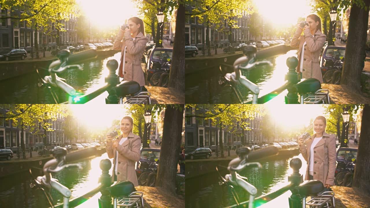 探索阿姆斯特丹的女人，站在运河旁边，用老式复古模拟相机拍照
