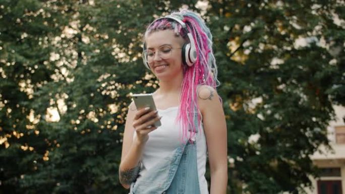 带着智能手机在户外跳舞的快乐年轻女子戴着耳机
