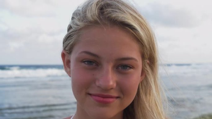 南非，美丽的年轻女子害羞地看着相机并在沙滩上大笑的4k超特写肖像