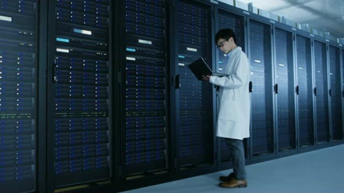 在数据中心: 穿着白大褂的男性IT专家站在服务器机架旁边，使用笔记本电脑运行维护诊断工具，进行控制，