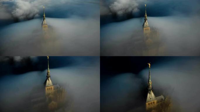 无人机在日出上飞行，圣米歇尔山城堡尖顶被浓雾覆盖，流入神秘的黑暗。