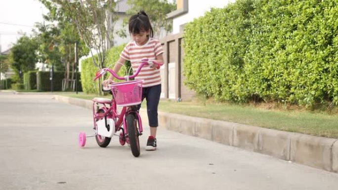 女孩在公园学习骑自行车