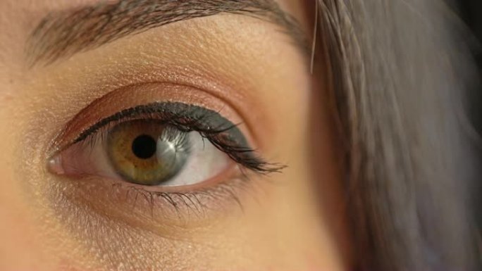 4k年轻女子用绿眼睛看着相机: 特写。