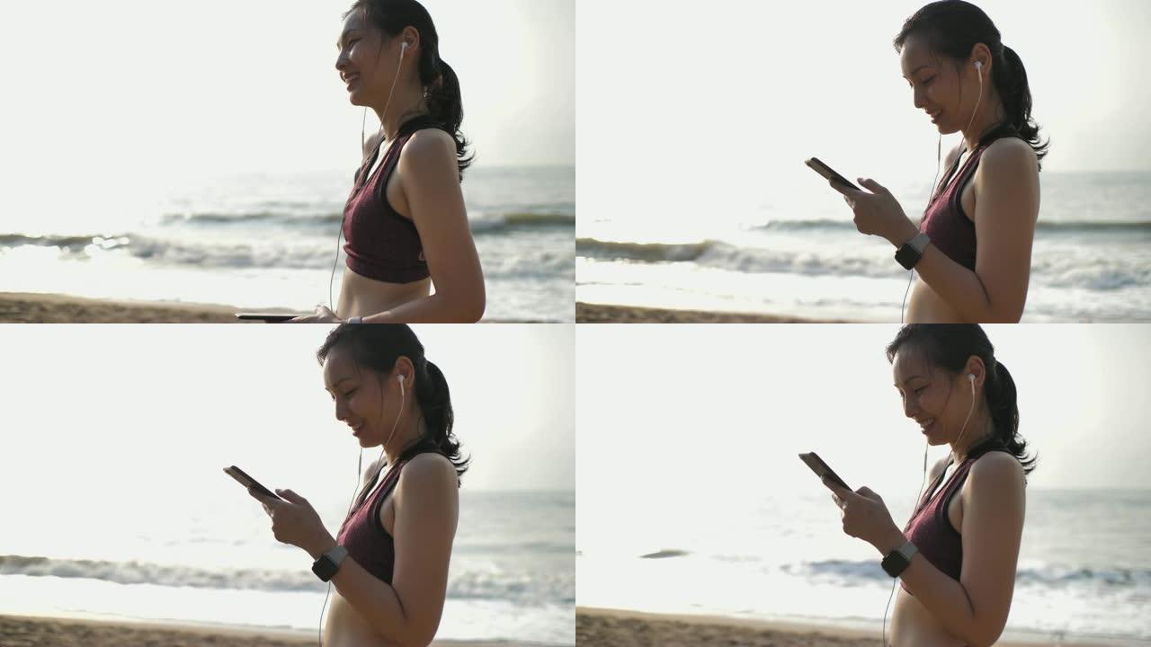 亚洲妇女在海滩上使用智能手机