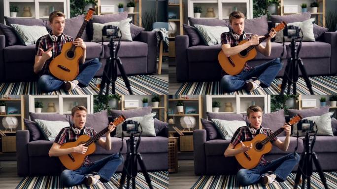 年轻的博客作者正在录制有关在家中使用相机为互联网博客弹吉他的教程