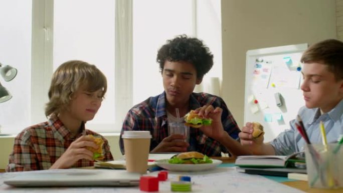 青少年学生在学校吃汉堡包