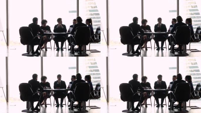 国际商务人士坐在办公室会议室桌上进行谈判