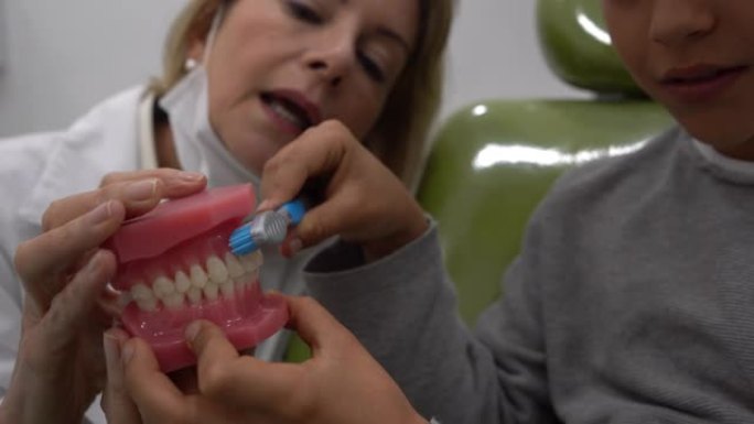 拉丁美洲男孩向牙医展示他如何使用牙盒和牙刷刷牙