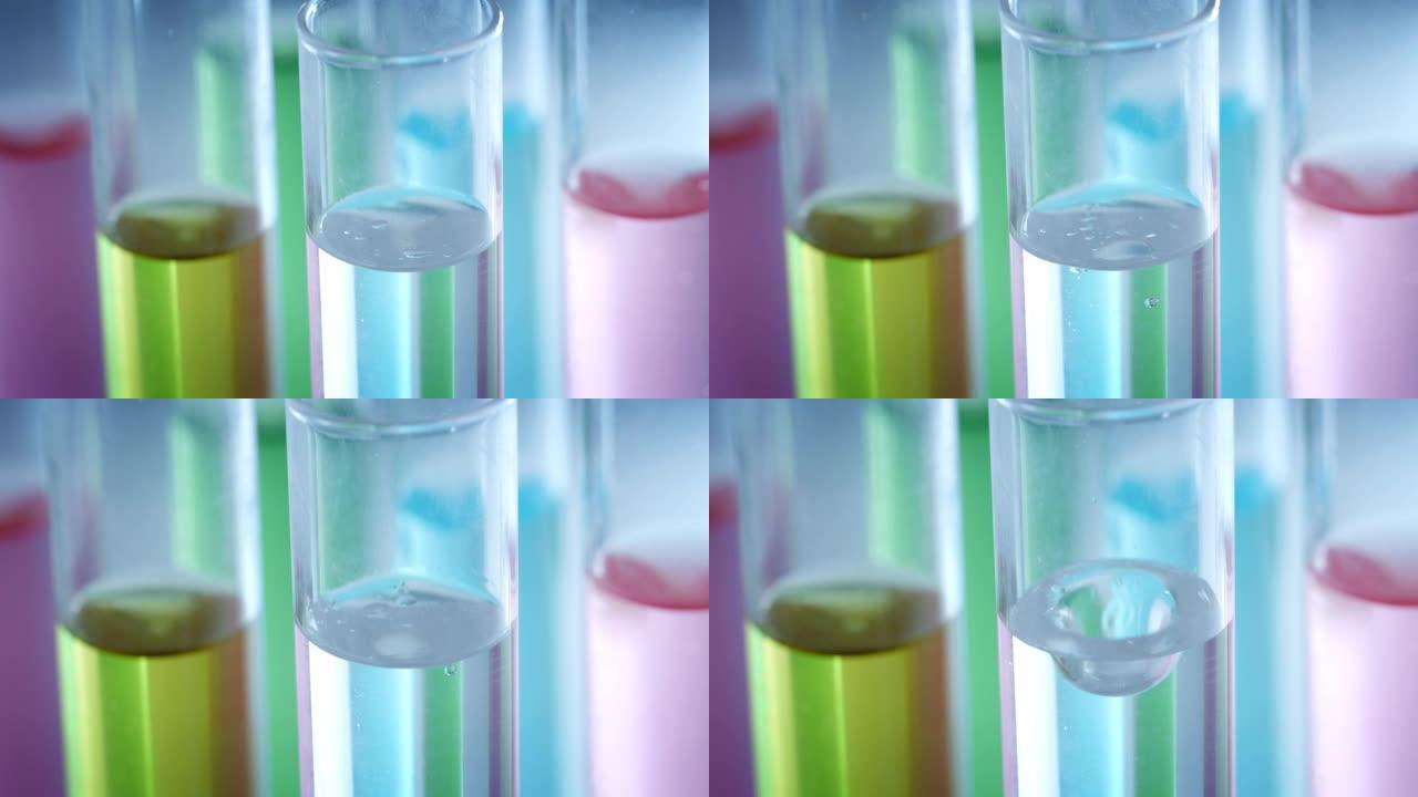 在科学实验室中分析了彩色液体中微粒子分子的慢动作宏观，以研究护肤和美容化妆品。