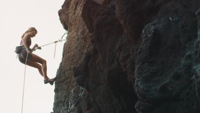 女人在岩壁上垂降攀岩女人在岩壁上垂降
