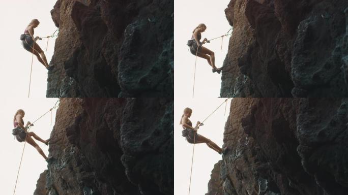 女人在岩壁上垂降攀岩女人在岩壁上垂降