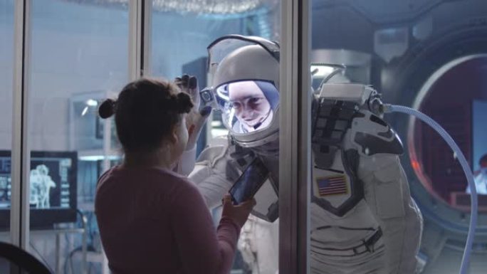 宇航员在出发前将手掌与女孩配对