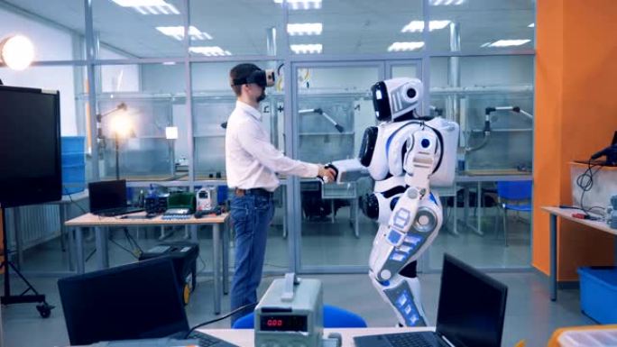男工人和机器人在房间里握手。VR游戏概念。