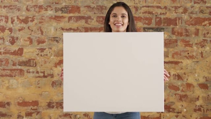 白人妇女在砖墙上拿着一个白色矩形
