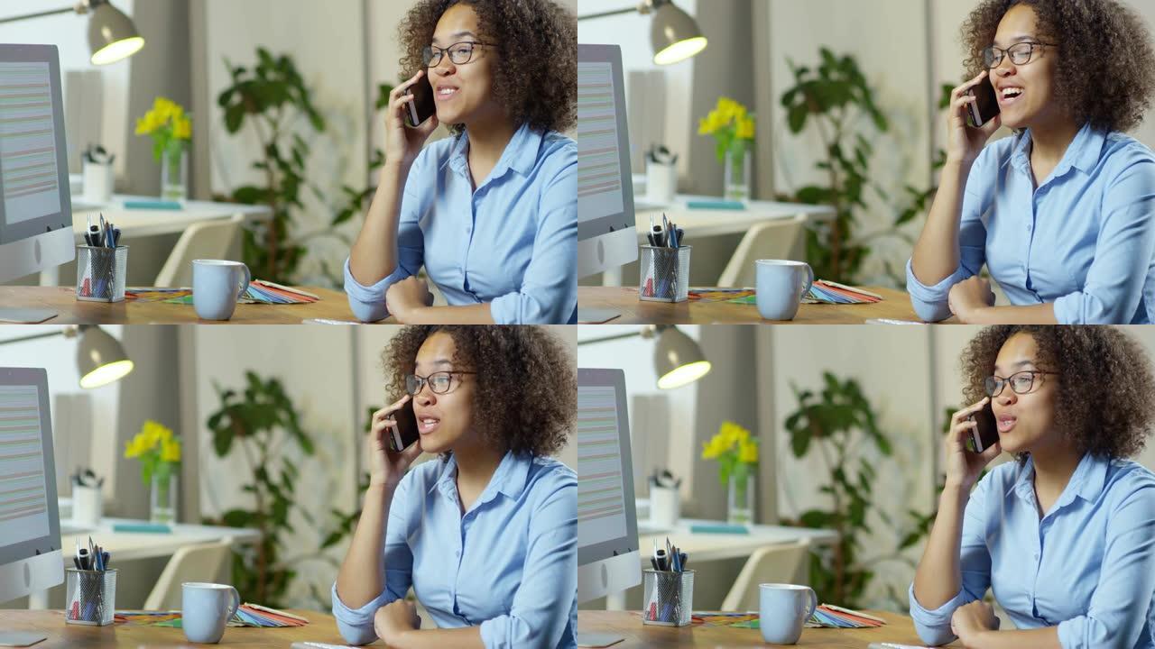友好的年轻黑人妇女在办公室里通过电话聊天