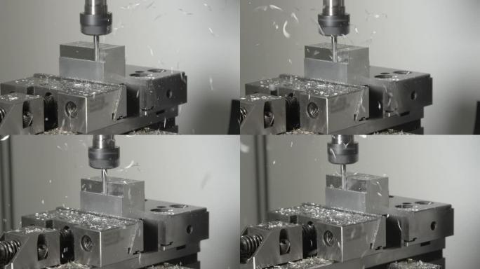 特写: 微小的芯片从车床工具加工的小金属立方体上飞出
