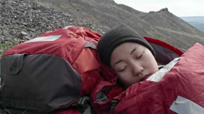 单人女徒步旅行者睡在户外的袋子里