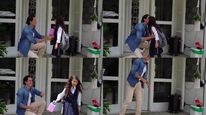 慈爱的爸爸把午餐盒交给女儿，并在离开学校之前在前廊亲吻她的再见