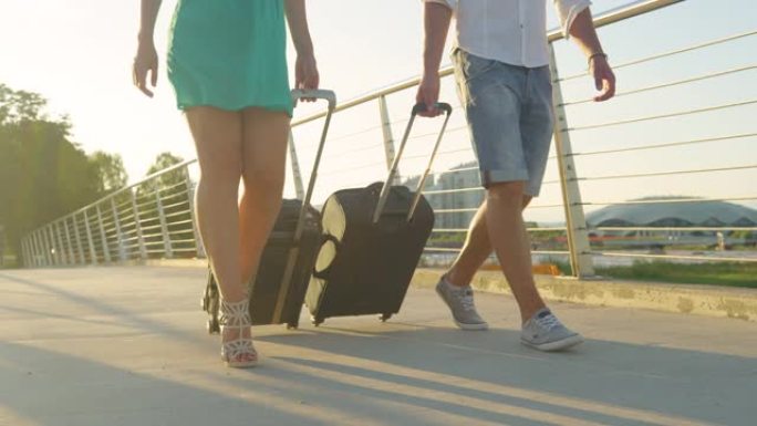 镜头耀斑: 穿着高跟鞋的女人和男朋友拖着行李箱去机场。