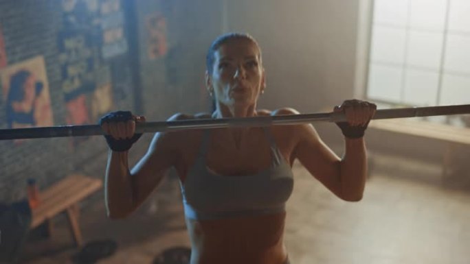 美丽强壮的女人在硬核健身房做引体向上。华丽的职业女运动员做力量，力量和交叉健身运动和日常锻炼程序。高