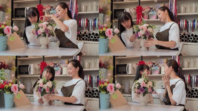 亚洲年轻母亲和10岁的女儿在封锁和新冠肺炎疫情后开业的商店里一起教制作美丽的花束。家庭时刻母亲和女孩