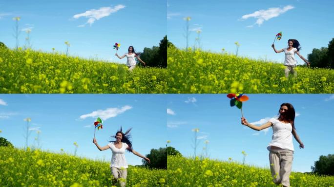 在阳光和风的日子里，一个快乐的年轻美丽的绿色女孩在新鲜风的能量的帮助下吹着五颜六色的风车。