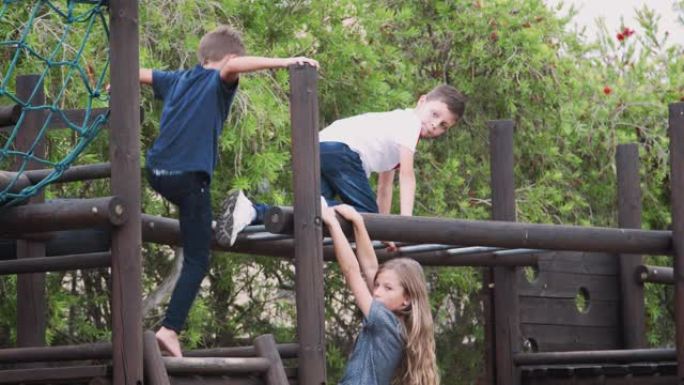 一群孩子在公园里和朋友在攀爬架上玩耍