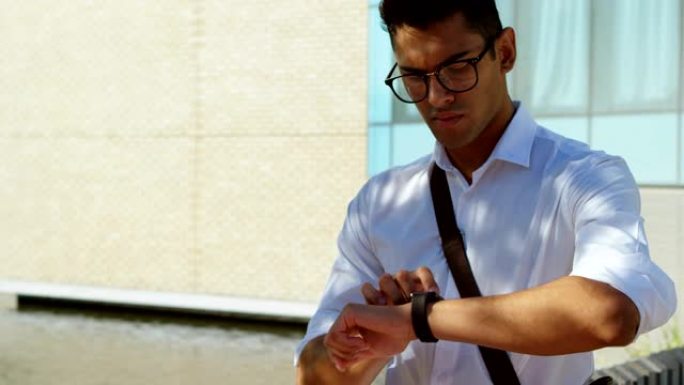 男子在4k街上检查他的智能手表