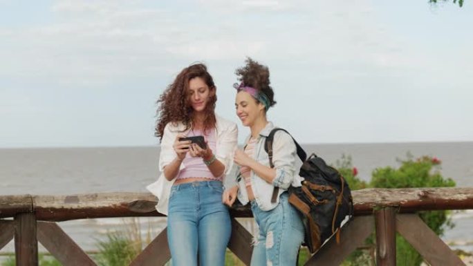 两个旅行的女性朋友在海滩边自拍