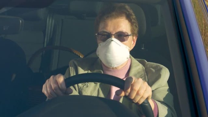 特写: 老年妇女在冠状病毒爆发期间开车时戴口罩