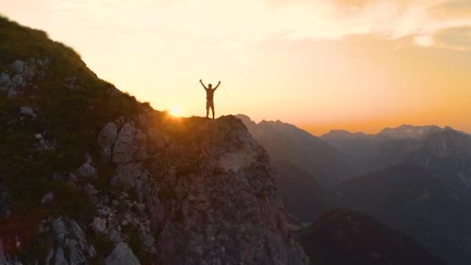 剪影: 欢快的男性徒步旅行者庆祝在阿尔卑斯山捕捉日落。