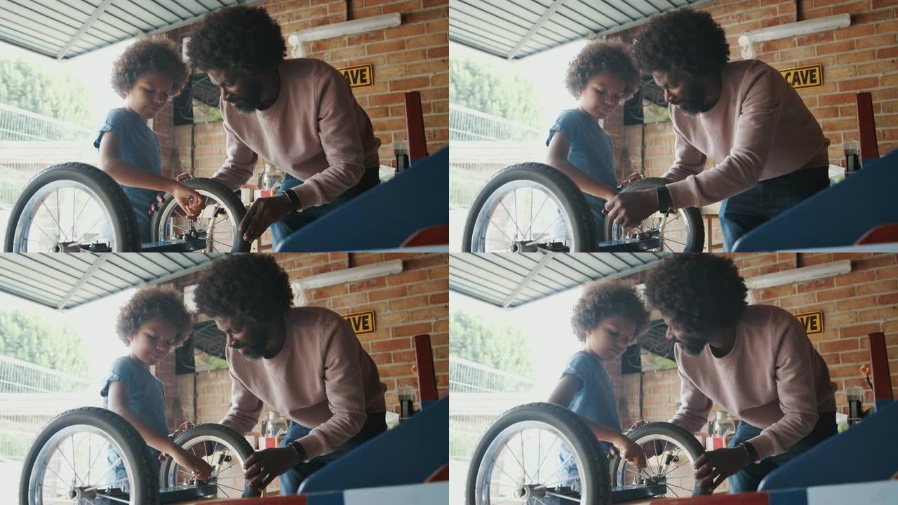 中年黑人父亲和十几岁的儿子站在工作台上，在他们的车库里一起建造赛车卡丁车，背光