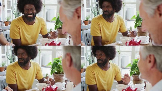中年黑人与朋友在咖啡馆吃早餐，特写镜头，选择性聚焦