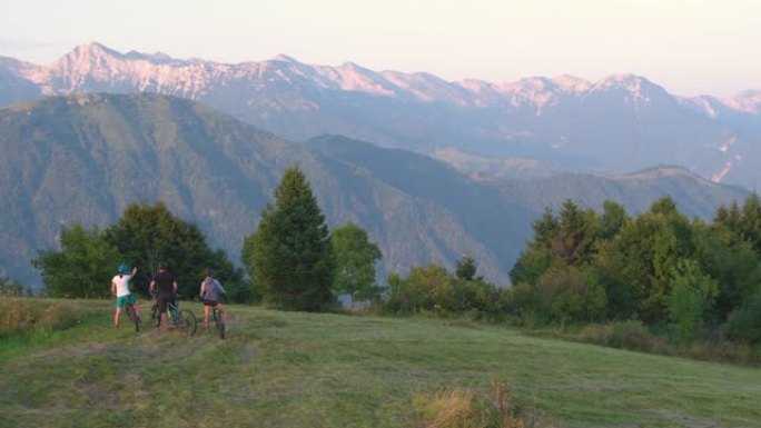 空中: 骑自行车的年轻游客环顾风景秀丽的夏夜大自然。