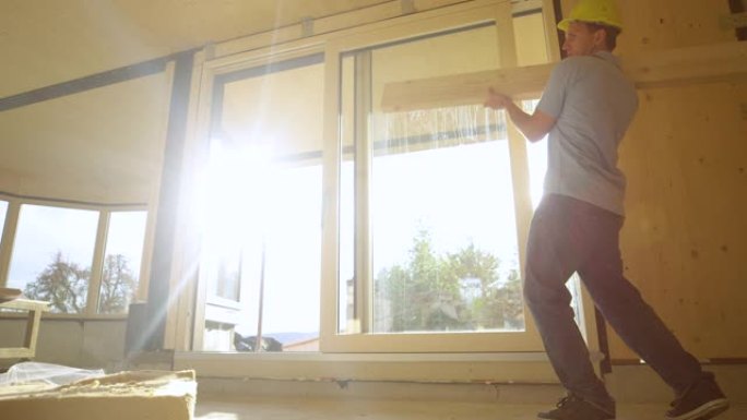 太阳耀斑: 承包商拿起一块木板，将其穿过CLT房屋。