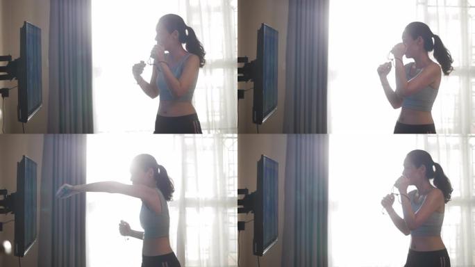 亚洲女子在家中玩带有VR模拟的拳击电子游戏