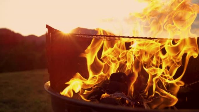 宏观: 燃料被倒在木炭烤架内燃烧的火上。