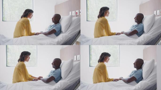 妻子在医院病床上探望和与病人丈夫交谈