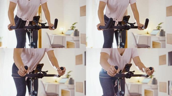 SLO MO女人在家骑自行车时调整健身车