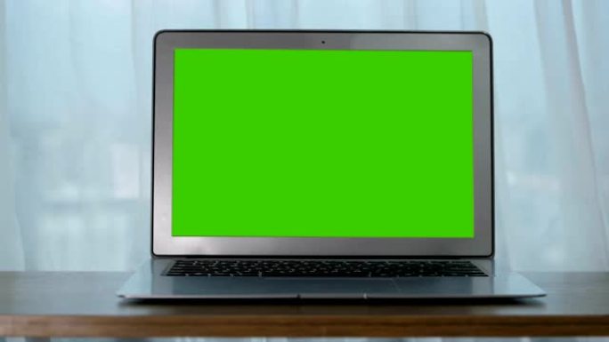 桌子上的笔记本电脑与绿色屏幕