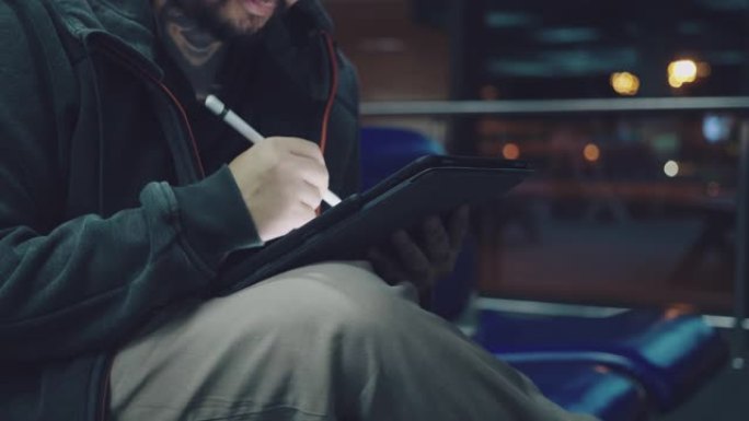 亚洲男性在国际机场等待飞行时使用笔记本电脑