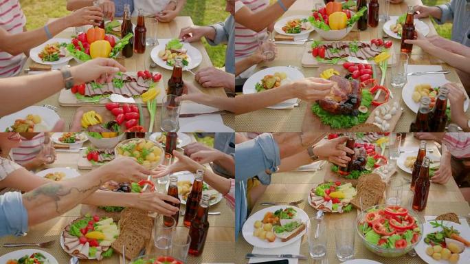 自上而下的移动镜头: 大家庭花园派对庆典，人们吃喝，传递菜肴。在阳光明媚的夏日享受假日乐趣。