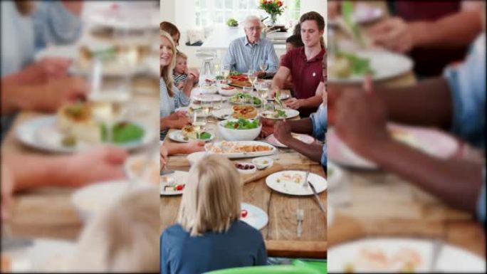 一大群家人和朋友坐在家里一起吃饭的照片 -- 慢动作拍摄