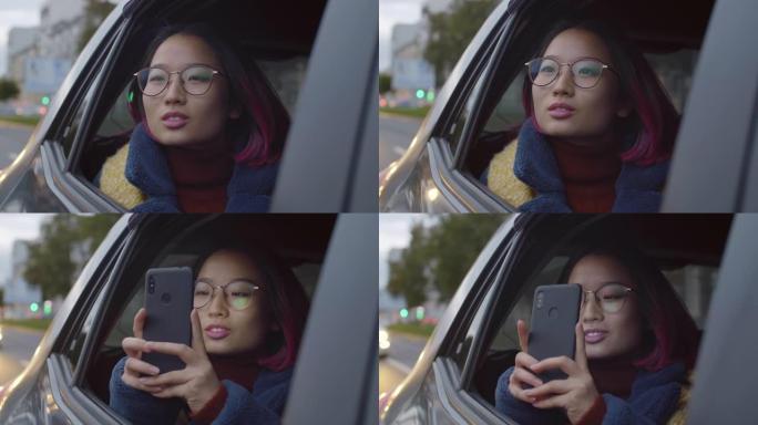 亚洲女性游客乘坐出租车并通过电话拍照