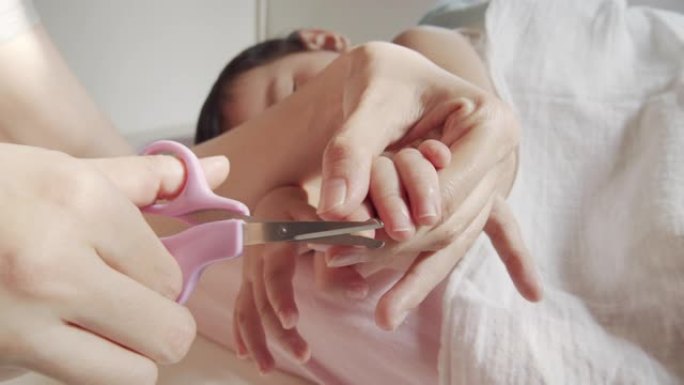 亚洲成年母亲在家里用指甲剪剪指甲的特写镜头