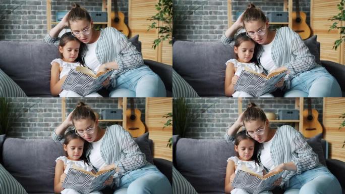 幸福的年轻家庭母女在家微笑着读儿童读物